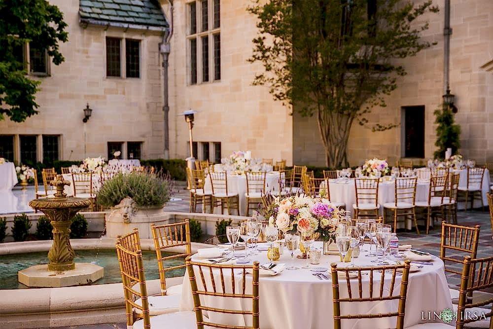 Wedding reception photography in Los Angeles, California at the Greystone Mansion with Lin and Jirsa and Orange Blossom Special Events Pink tables with elegant brass chairs with a water fountain in the background, in front of the Greystone Mansion, located in Beverly Hills, California